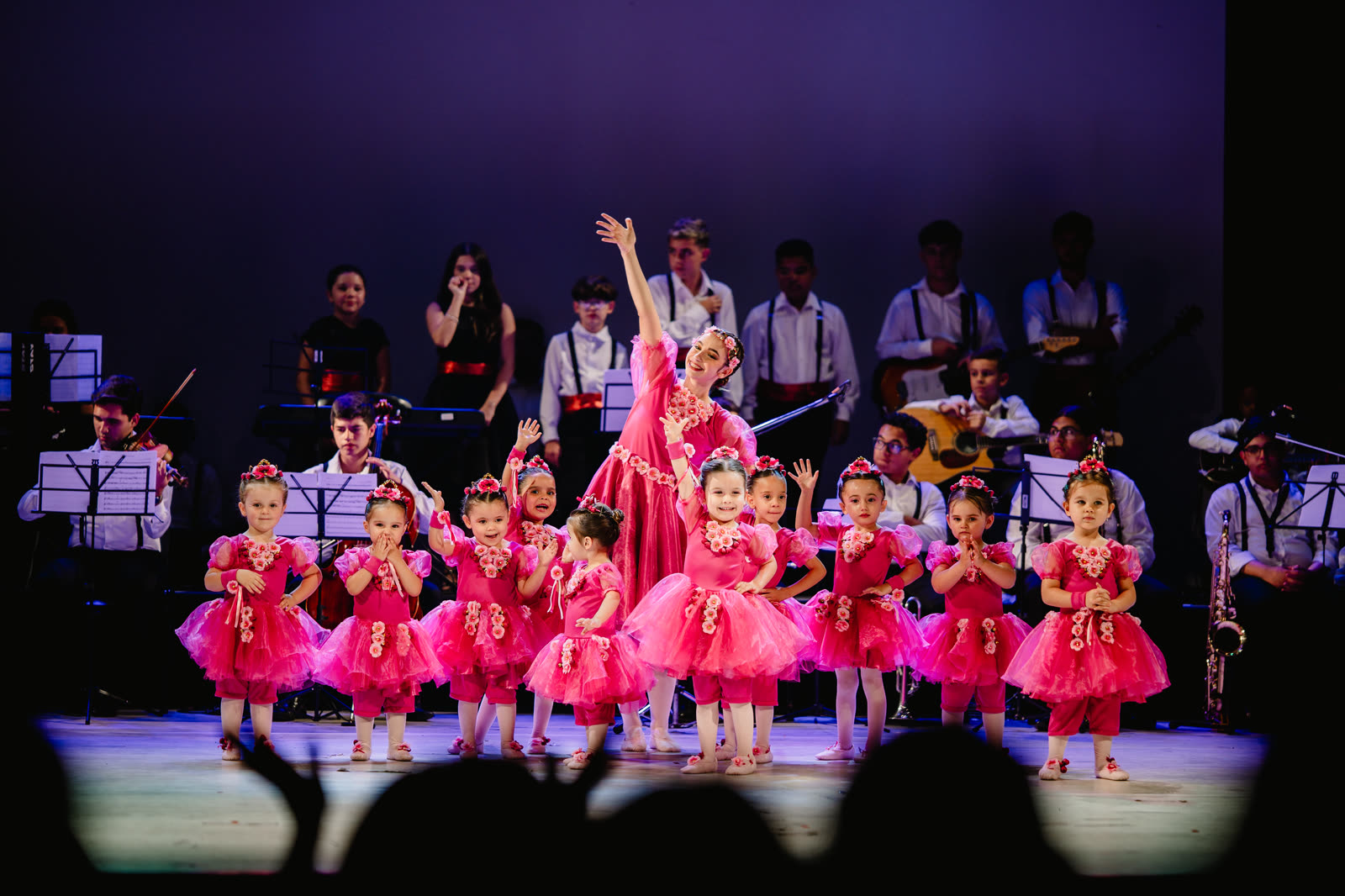 Turma do Baby Class se apresentando no palco, com a banda ao fundo