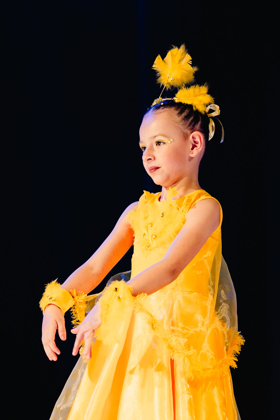 Menina de figurino amarelo dançando